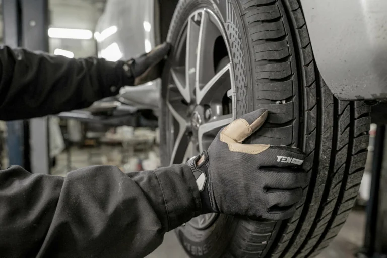 Mechanic with gloves on changing a car tyre