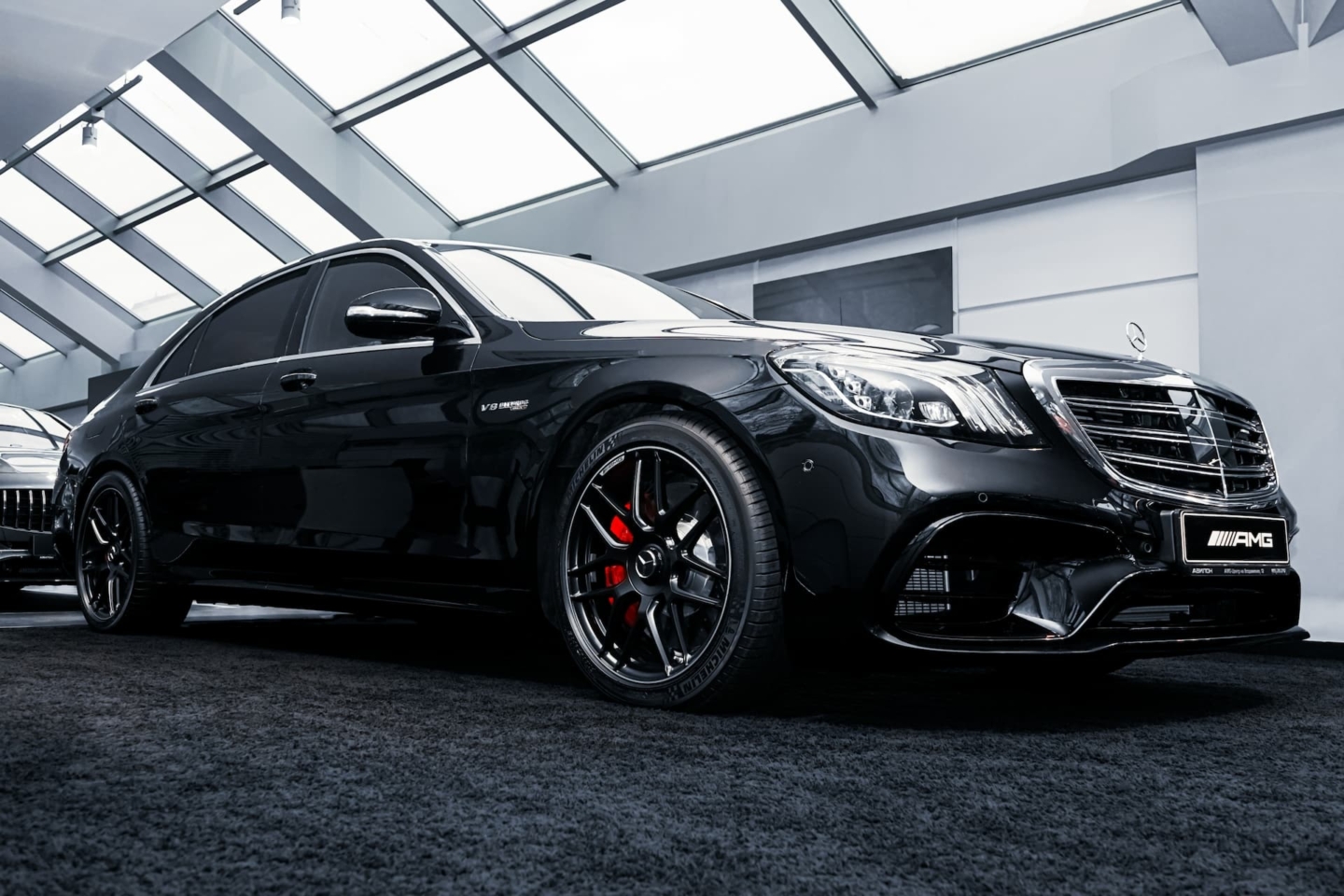 A shiny black Mercedes-Benz C63 AMG parked in a showroom