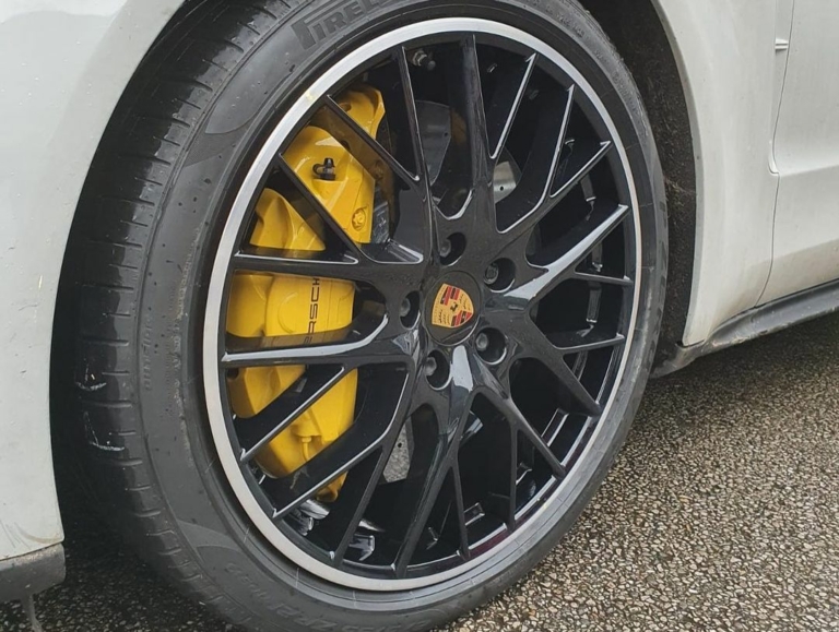 A black Porsche alloy wheel after undergoing the powder coating process
