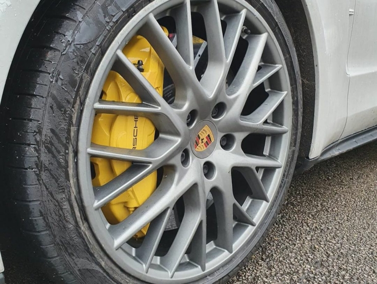 A silver/grey Porsche alloy before the alloy wheel powder coating process